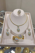 Jewelry set including necklace, earrings, and bracelet on a display stand with a blurred background.